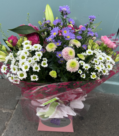 Petal Paradise - A lively bouquet featuring a bright mix of vibrant seasonal blooms. Complemented by lush green foliage and presented in a beautiful packaging, this arrangement is perfect for adding a pop of colour to any occasion