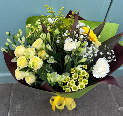 Citrus Sunrise - Capture the essence of a golden meadow with this stunning bouquet of yellow, white, and orange flowers. Presented in a stylish packaging it's perfect for adding natural beauty to any space