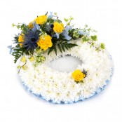 SYM-319 White Massed Wreath with Blue & Yellow Spray